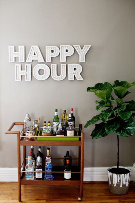A Beautiful Mess Happy Hour marquee sign over a bar cart
