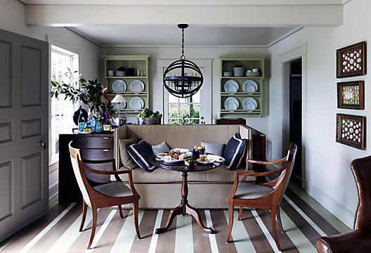 This unconventional dining room is hardly standard. It consists of a knole sofa, an end table and a pair of armchairs. 
