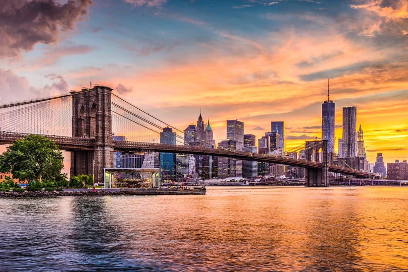 New York City Skyline on the East River with Brooklyn Bridge at sunset