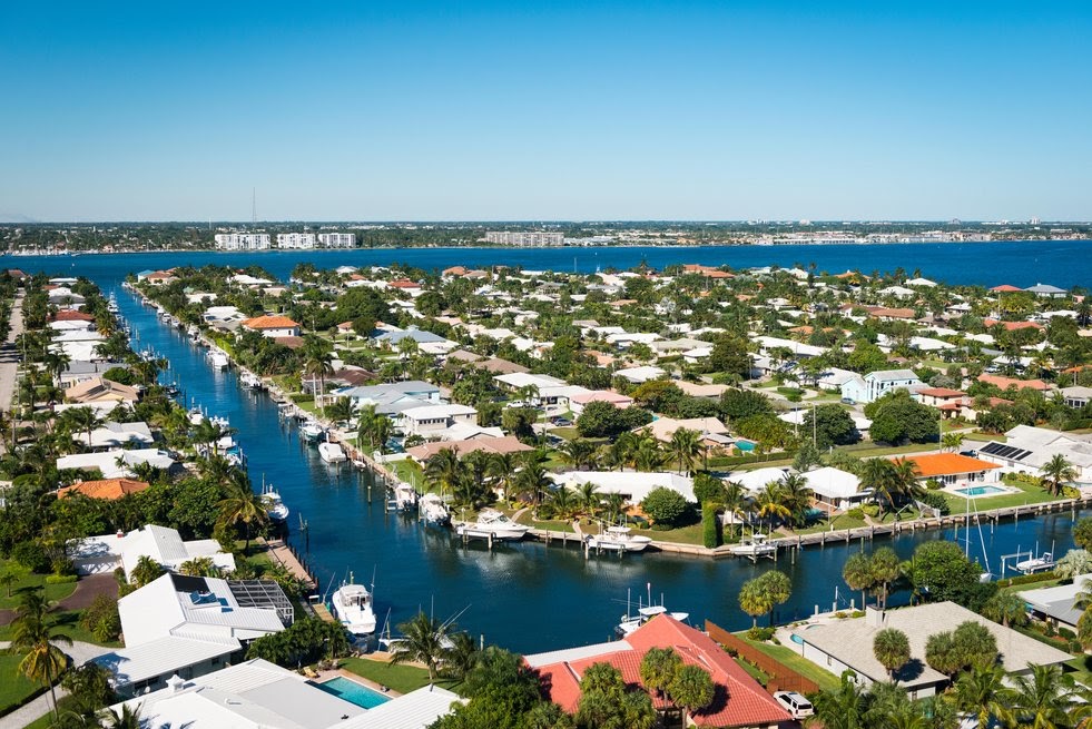 Florida Palm Beach West Singer Island intercostal luxury houses with boats moored at bottom of gardens