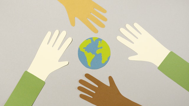 Hand reaching out to one another protecting the planet earth.