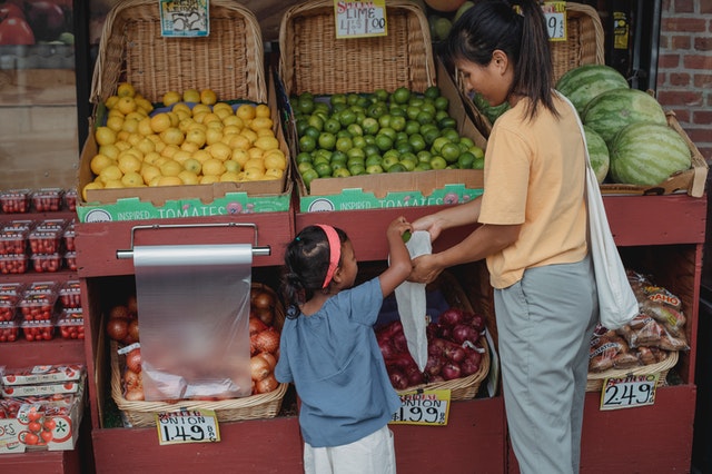 A mother and child buying fruits at the stand