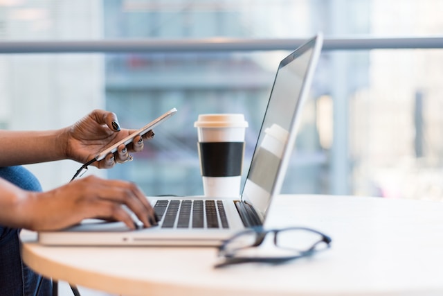 girl working on her laptop while drinking coffee