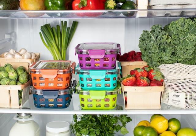 organized fridge with fruits, vegetables, and prepped meal 