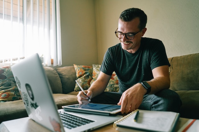 Person sitting in living room working from home on laptop.