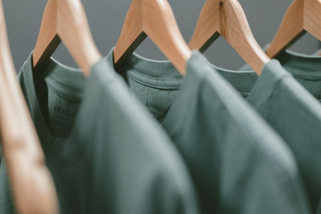 the upper part of three green T-shirts hanged 